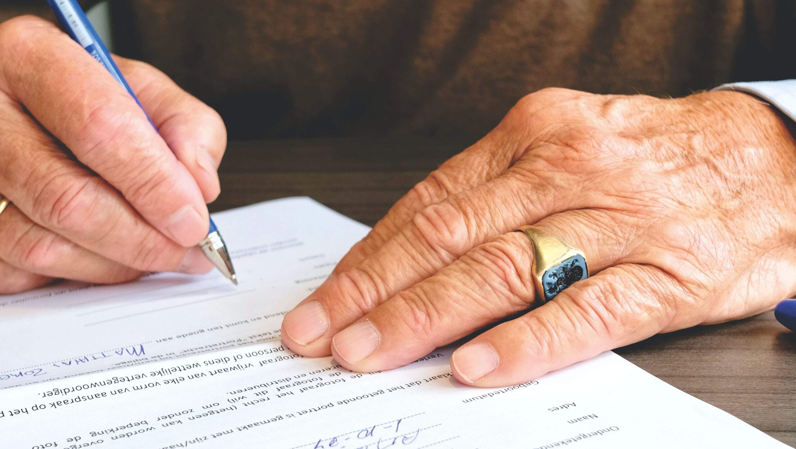 ¿Qué pasa cuando firmas un pagaré?: manos de hombre firmando un título de crédito.