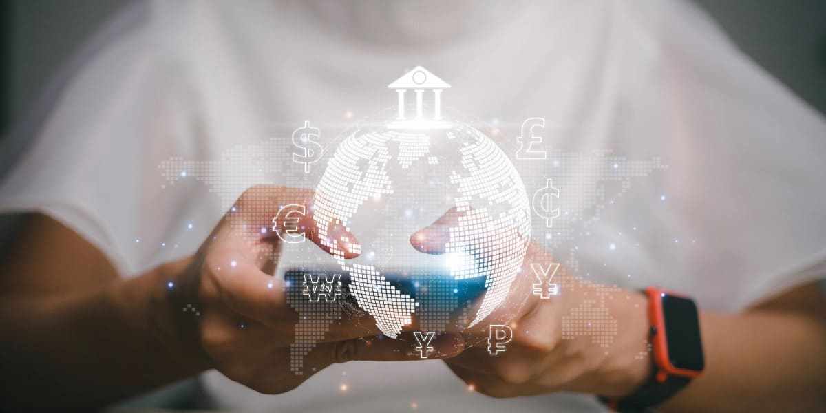 Hombre sosteniendo su teléfono celular con un gráfico de un mundo, un logo de un banco y de distintas monedas para representar qué es un pago con SPEI.
