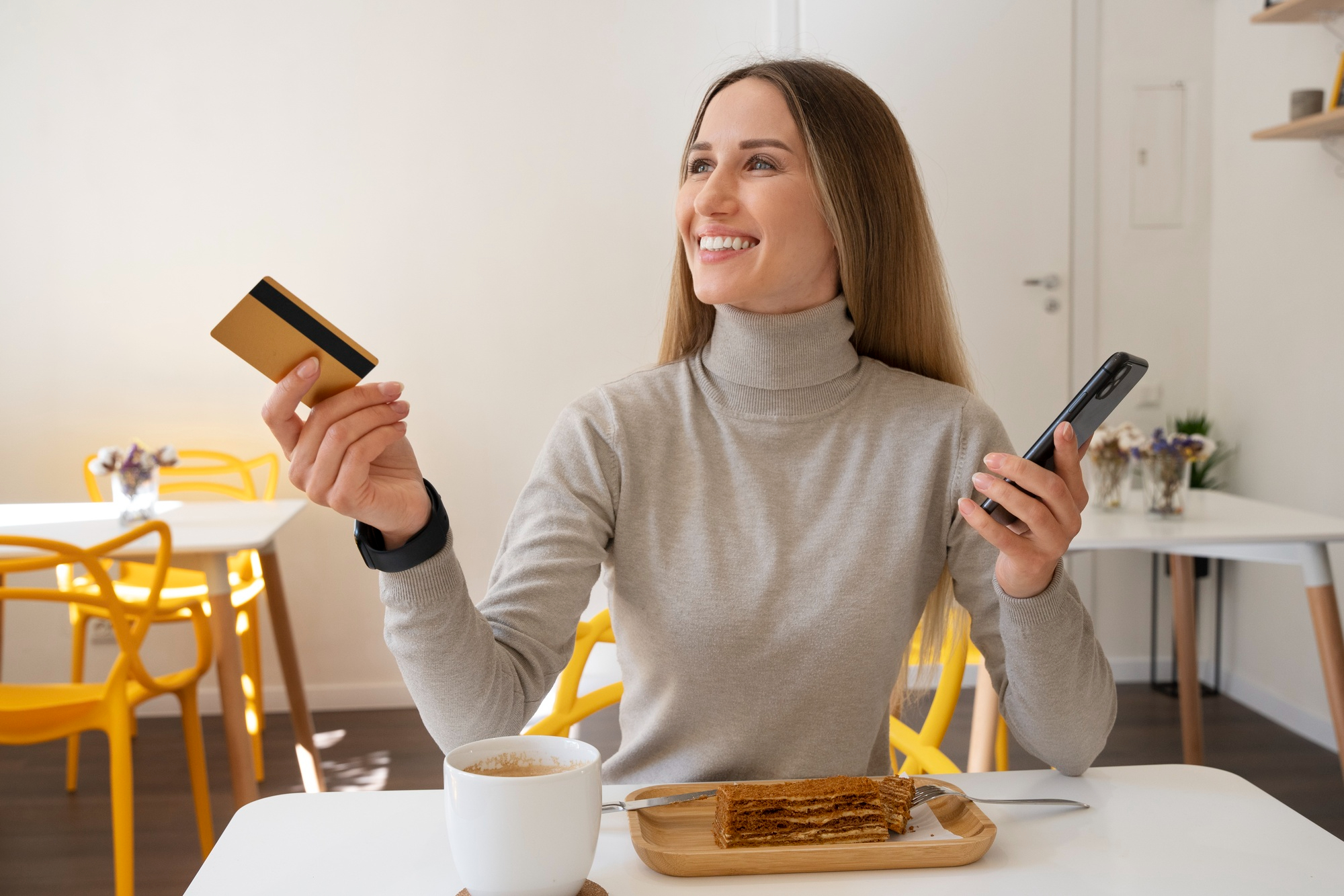 Mujer pagando su comida en un restaurante con su tarjeta de crédito para reunir puntos American Express.