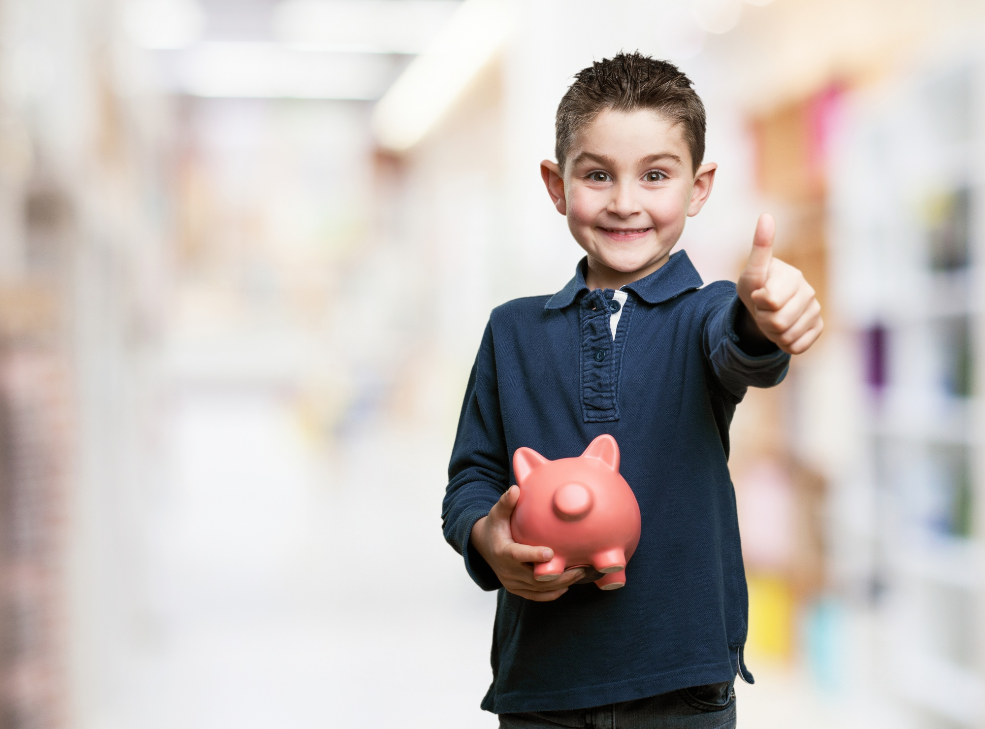 Niño emocionado por depositar sus ahorros en su cuenta Suma Menores Banorte.