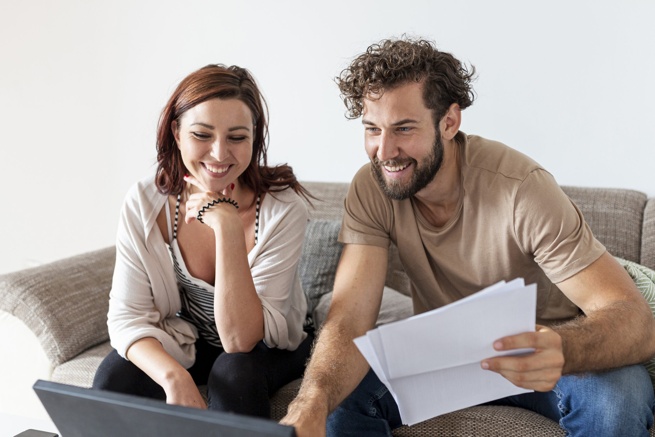 Mujer y hombre felices revisando sus finanzas en pareja