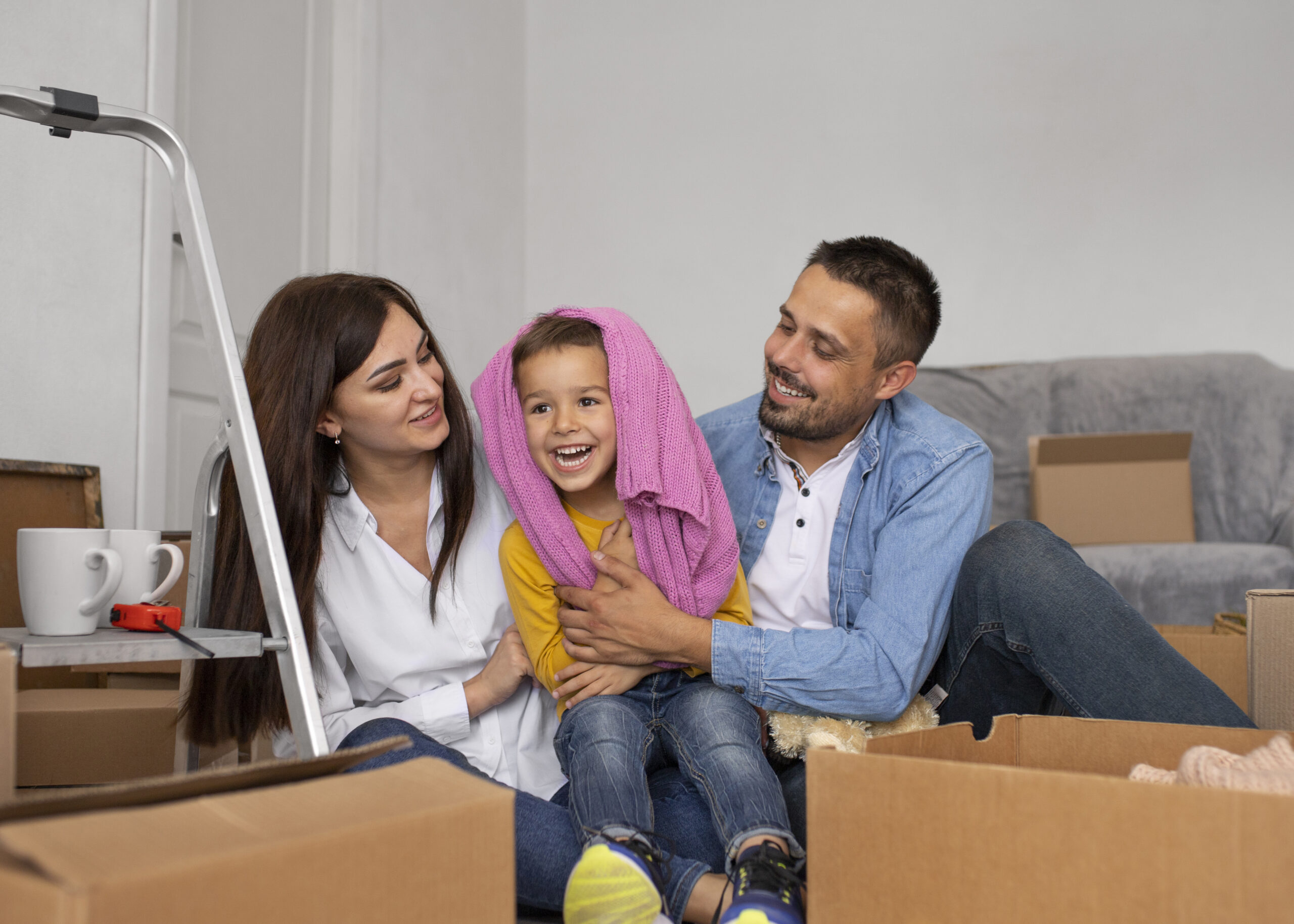 Familia feliz desempacando en su nueva casa que cuenta con seguro para vivienda.