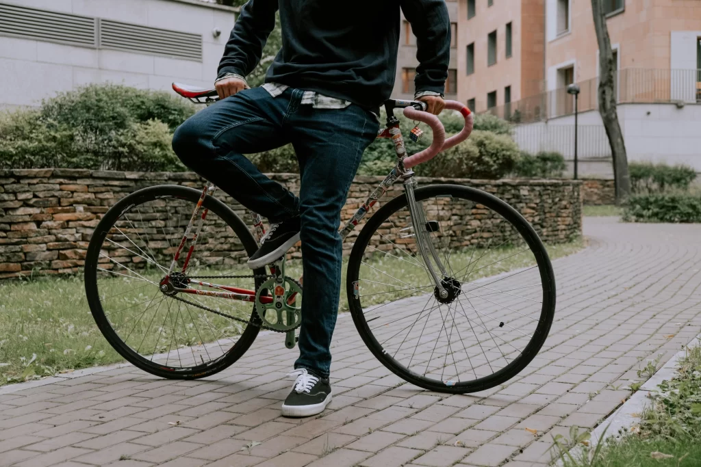 Hombre joven recargado en una bicicleta, un artículo que algunos seguros de gadgets también protegen.