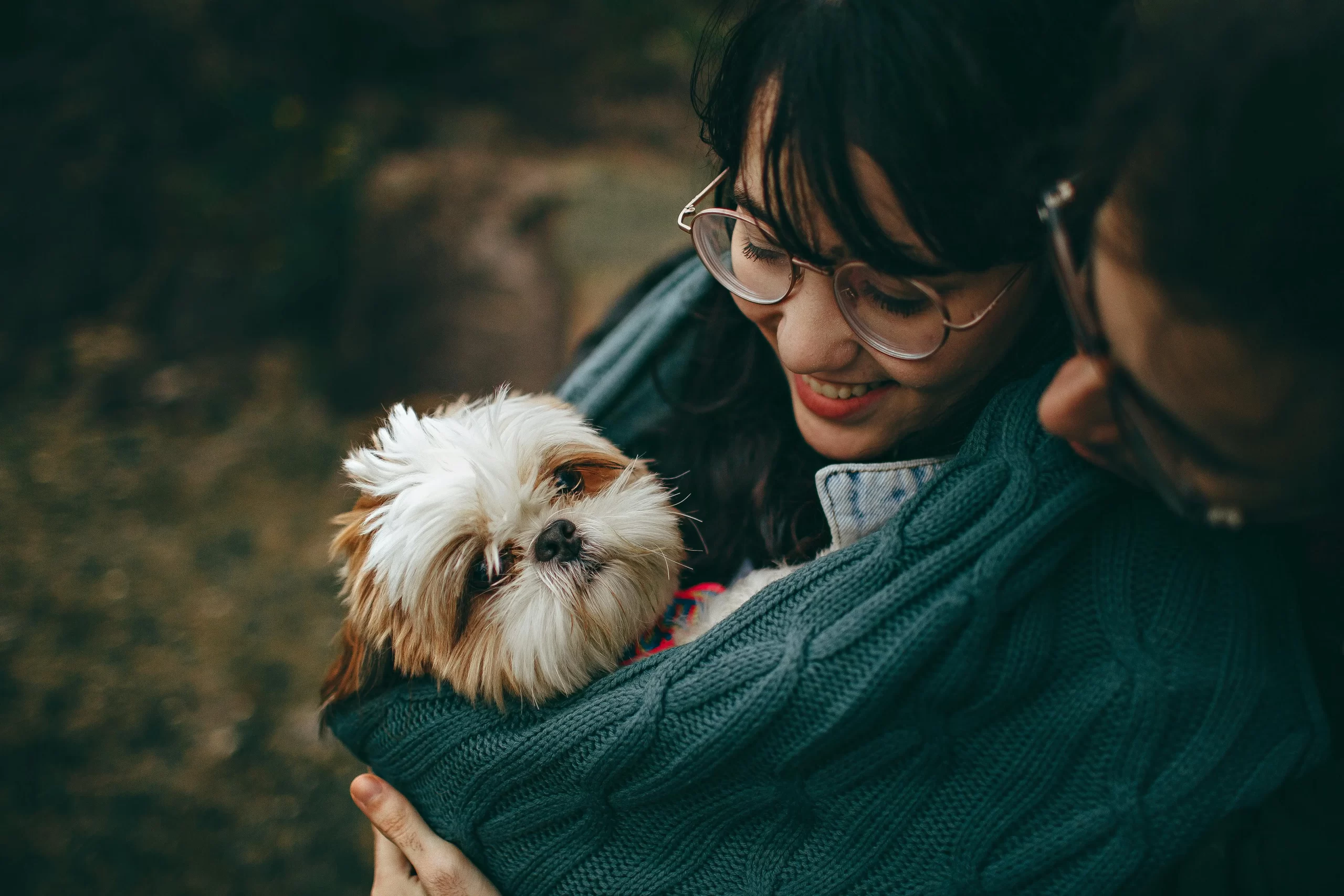 Pareja con su perro de raza pequeña que cuenta con seguro para mascotas.