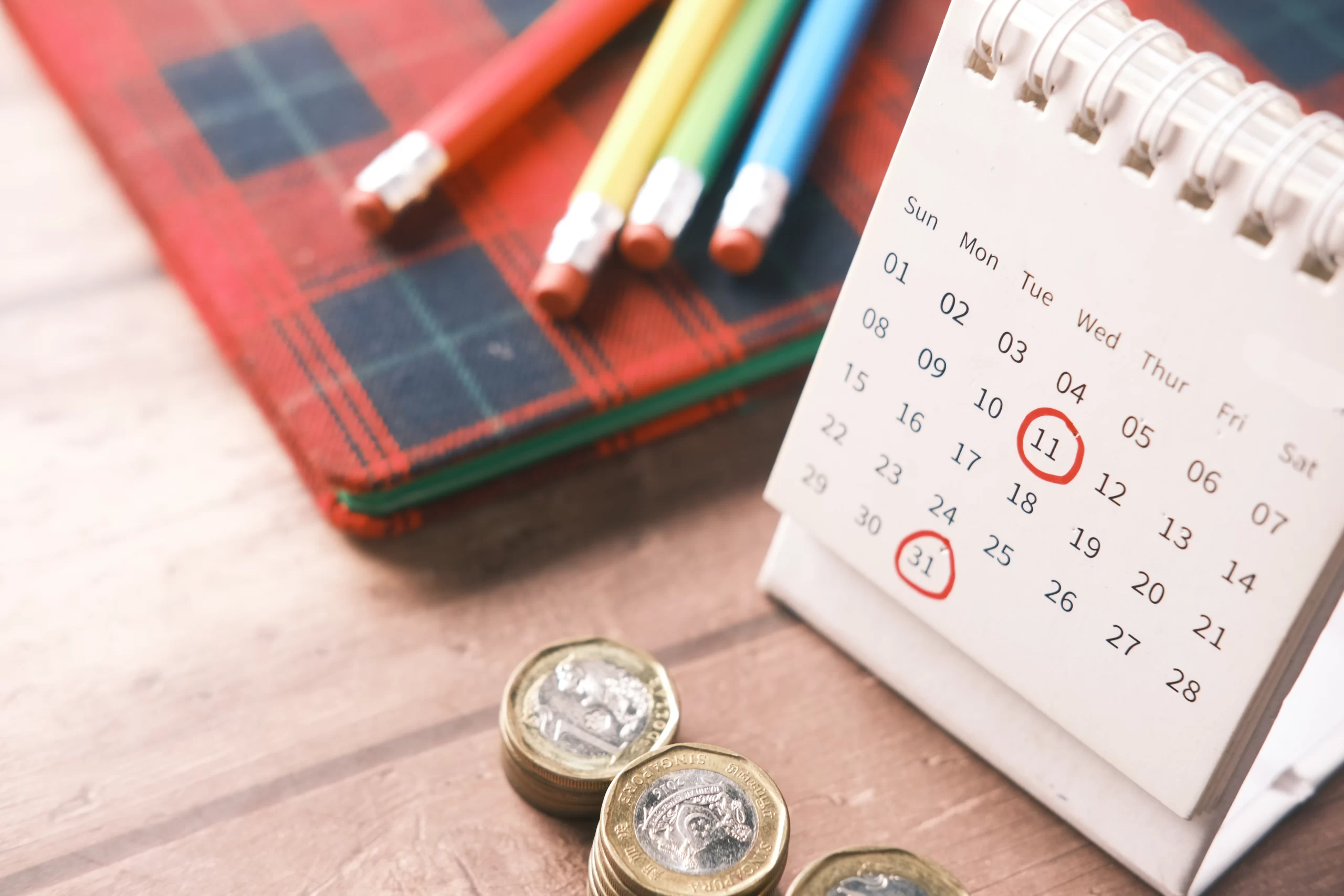 Fotografía de un calendario financiero con unas monedas junto.