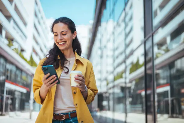 Persona usando su móvil con tranquilidad en la calle después de contratar un seguro para celular.