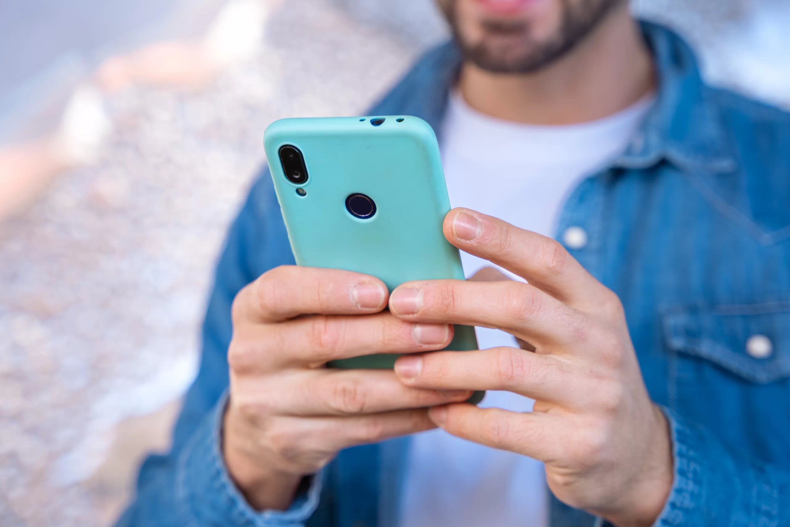 Hombre usando su teléfono celular después de contratar un seguro para celular.