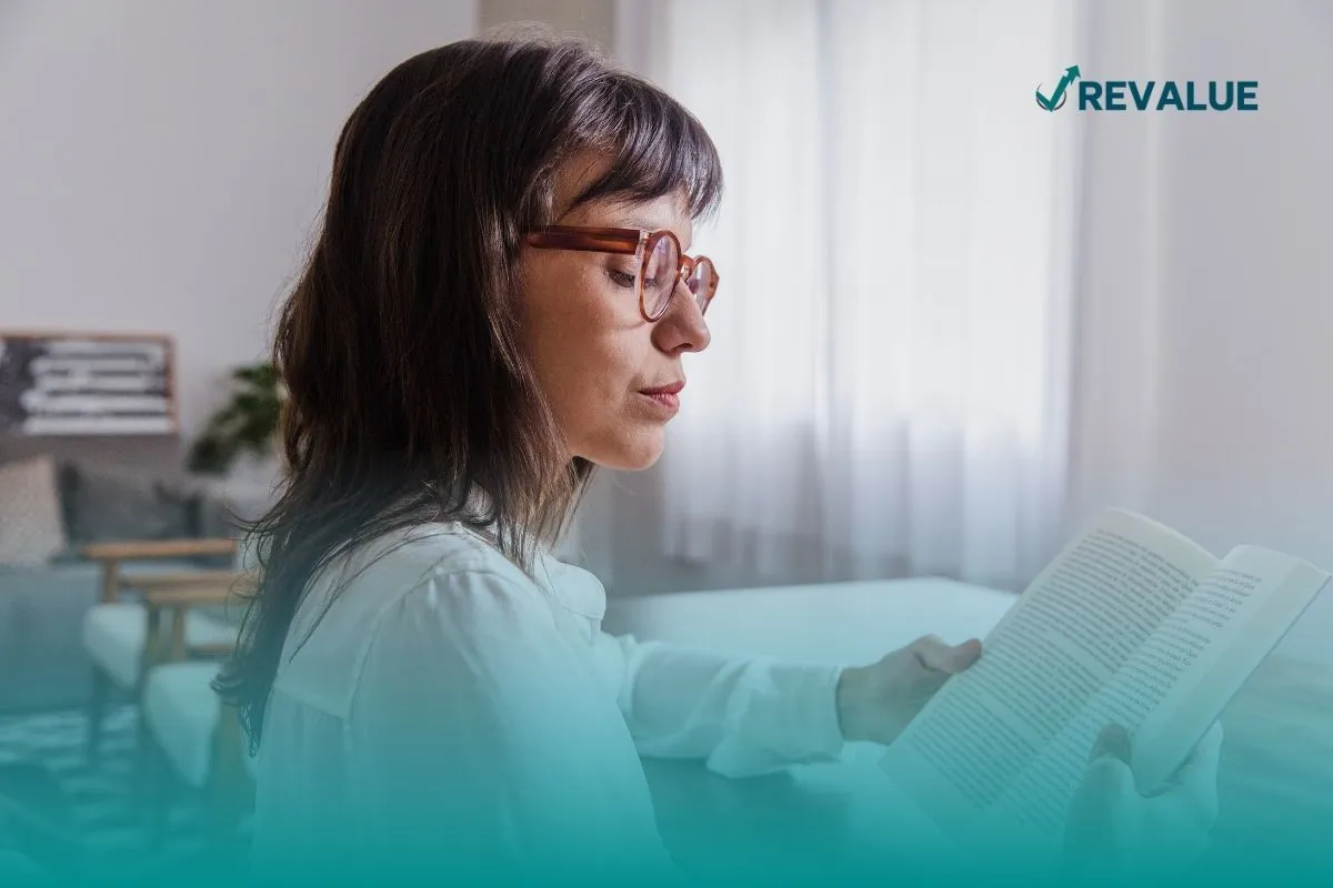 Mujer leyendo algunos de los mejores libros de finanzas personales.