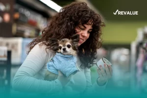 Mujer cargando a su perro mientras hace las compras y piensa cuál es el mejor seguro para perros.