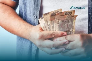 Persona sosteniendo billetes de quinientos pesos que cuenta con un seguro contra robo de efectivo.