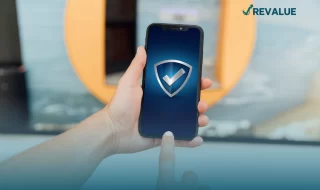 Persona sosteniendo un celular mostrando un escudo en la pantalla que