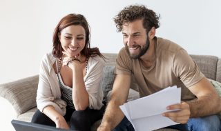 Mujer y hombre felices revisando sus finanzas en pareja