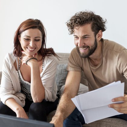Mujer y hombre felices revisando sus finanzas en pareja