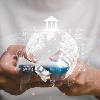 Hombre sosteniendo su teléfono celular con un gráfico de un mundo, un logo de un banco y de distintas monedas para representar qué es un pago con SPEI.