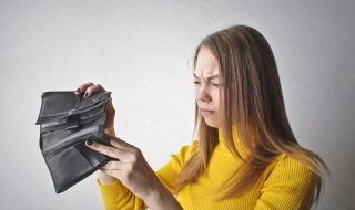 Mujer revisando su falta de dinero en la cartera durante el día mundial del ahorro