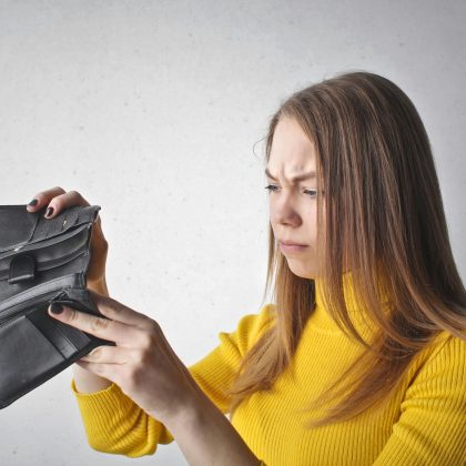Mujer revisando su falta de dinero en la cartera durante el día mundial del ahorro