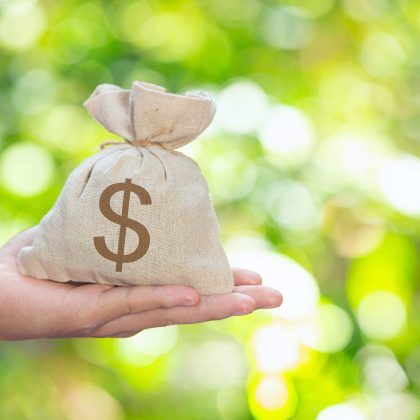 Mano sosteniendo una bolsa de dinero representando dónde se puede solicitar un préstamo personal sin tantos requisitos.