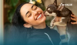 Mujer cargando a su perro mientras la lame después de investigar las aseguradoras para mascotas que lo protegen de accidentes y enfermedades.