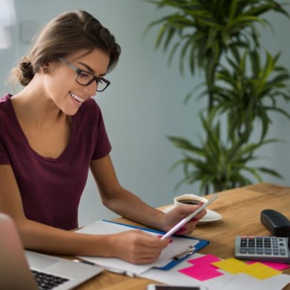 Mujer en un escritorio organizando sus finanzas y haciendo su portabilidad de nómina a Banamex.