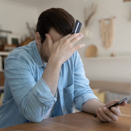 Hombre preocupado por no saber qué pasa si no puede pagar su tarjeta de crédito