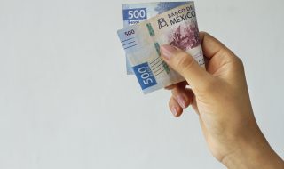 Mano sosteniendo un billete de 500 pesos obtenido de su reembolso del SAT