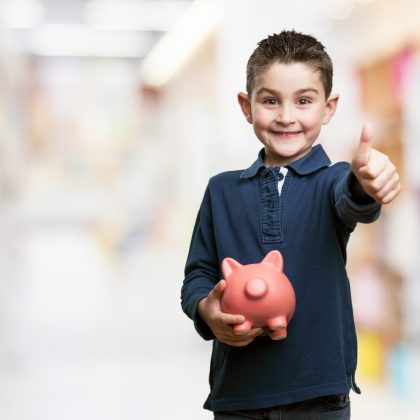Niño emocionado por depositar sus ahorros en su cuenta Suma Menores Banorte.
