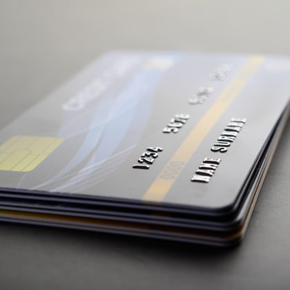 Fotografía de unas tarjetas de crédito apiladas con la Tarjeta de Crédito Empresarial BBVA hasta arriba.