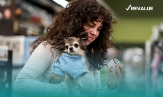 Mujer cargando a su perro mientras hace las compras y piensa cuál es el mejor seguro para perros.
