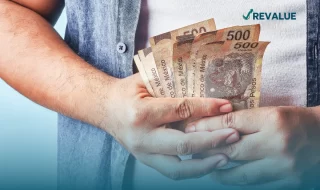 Persona sosteniendo billetes de quinientos pesos que cuenta con un seguro contra robo de efectivo.