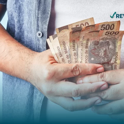 Persona sosteniendo billetes de quinientos pesos que cuenta con un seguro contra robo de efectivo.