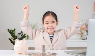 Niña que puede ocupar su dinero de forma inteligente gracias a que sus tutores saben cómo enseñar a los niños a ahorrar.