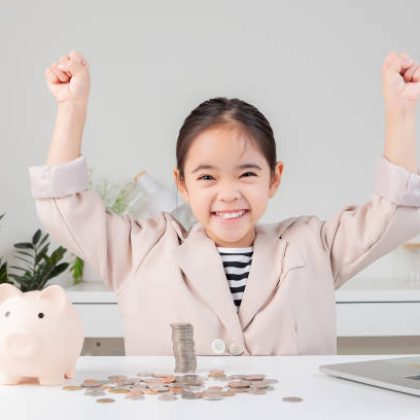 Niña que puede ocupar su dinero de forma inteligente gracias a que sus tutores saben cómo enseñar a los niños a ahorrar.