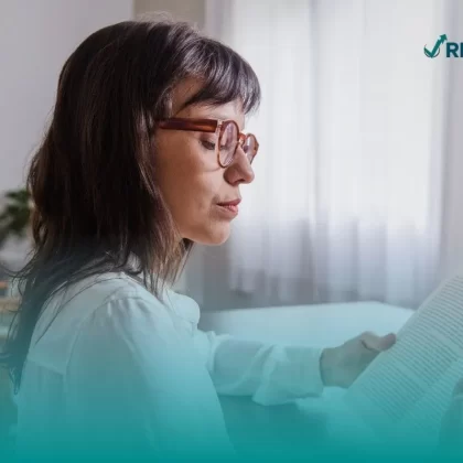 Mujer leyendo algunos de los mejores libros de finanzas personales.