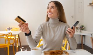 Mujer pagando su comida en un restaurante con su tarjeta de crédito para reunir puntos American Express.