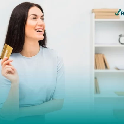 Mujer posando con su tarjeta de crédito que cuenta con seguro para tarjetas de crédito.