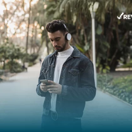 Persona caminando con calma en la calle con su celular gracias a que ha contratado el seguro Bancomer para celular.